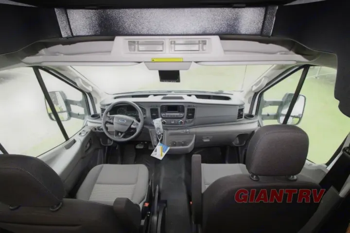 Inside an RV rental, the spacious driver's cabin features a dashboard, steering wheel, and comfy front seats.. Forest River Coachmen Cross Trail XL 2022