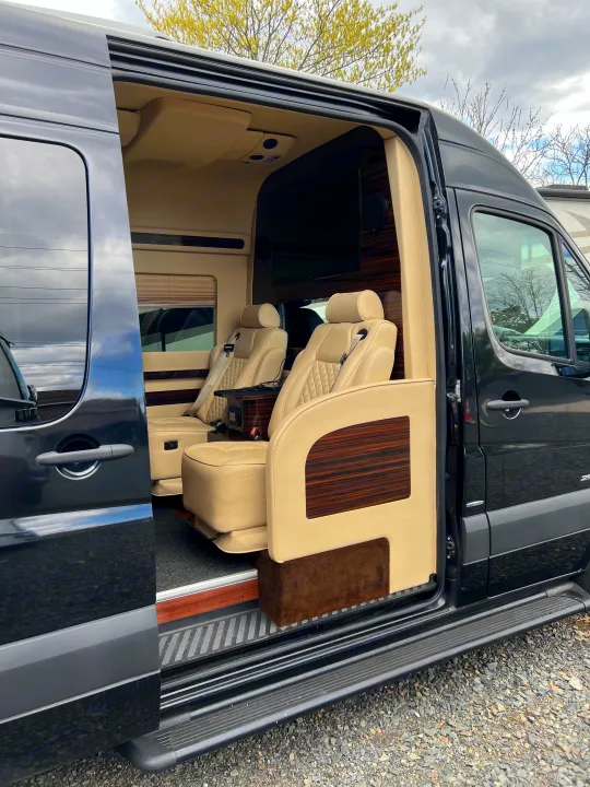 Experience luxury RV rental travel: this van features plush cream leather seats, wood accents, and a TV for comfort.. Mercedes-Benz Sprinter 2016