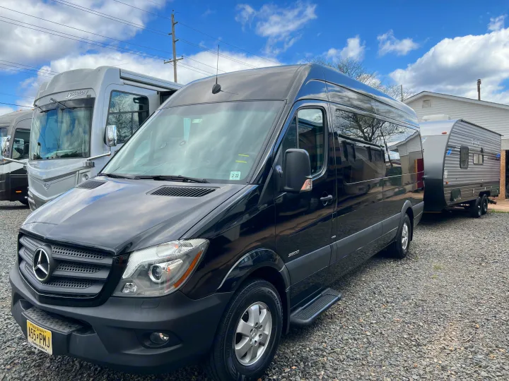 A black Mercedes-Benz Sprinter van and a large motorhome with a travel trailer, available for rv rental.. Mercedes-Benz Sprinter 2016