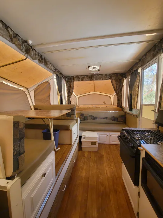 Spacious pop-up camper interior for rv rental. View shows kitchen, dining area, and two extended sleeping berths.. Starcraft Centennial 2005