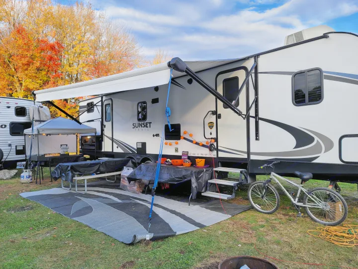 Autumn RV rental campout with festive Halloween decor, a picnic area, and an outdoor kitchen setup.. Crossroads RV Sunset Trail Super Lite 2018