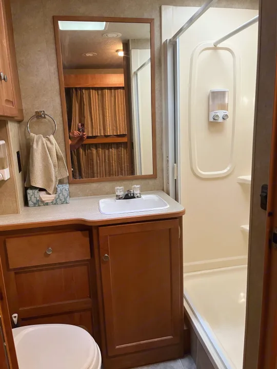 RV rental bathroom with sink, mirror, shower, and toilet area. Compact interior.. Winnebago Access 2008