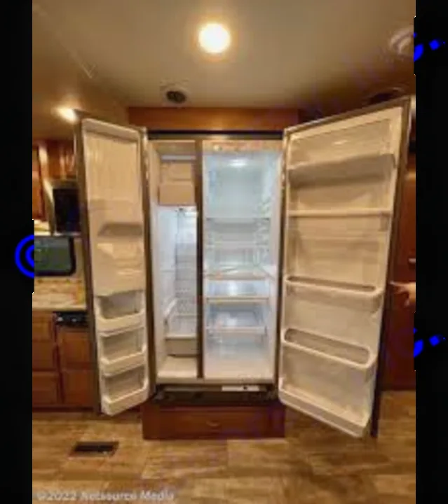 Spacious RV rental kitchen featuring an open, empty full-size side-by-side refrigerator, showcasing interior amenities.. Thor Challenger 2017