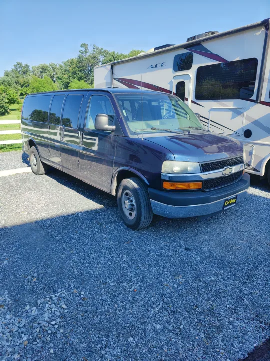 Dark blue van and white RV parked on gravel. Consider an RV rental for your next travel adventure!. Chevrolet Other 2012