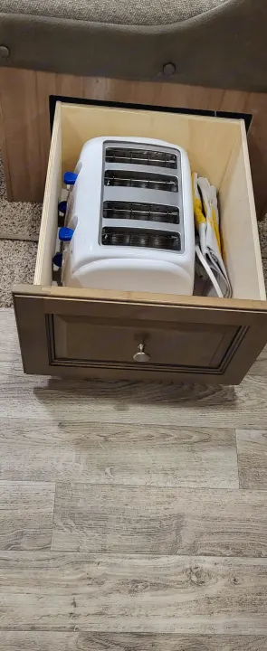 Compact RV rental storage: A white four-slice toaster and work gloves neatly fit in a pull-out drawer.. Forest River Flagstaff Micro Lite 2018