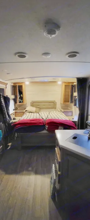 RV rental bedroom view with a bed, cabinets, and a disturbing doll peeking from the left cabinet.. Forest River Flagstaff Micro Lite 2018