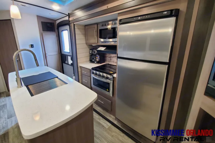 Spacious RV rental kitchen with island, stainless steel appliances, and modern design.. Crossroads Sunset Trail 2022