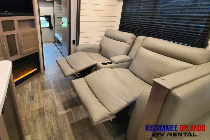 Spacious RV interior with reclining theater seating, electric fireplace, and modern decor for your rv rental comfort.. Crossroads Sunset Trail 2022