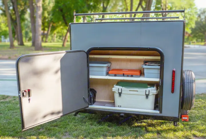 Get ready for adventure with an RV rental! This camping trailer's open rear reveals organized storage: cooler, stove, bins.. Superior Lite Camper Deluxe 2022