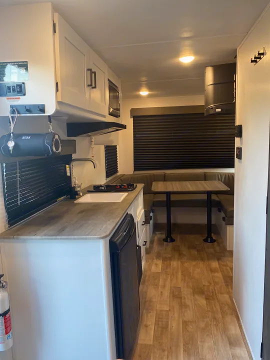 Explore this functional RV rental interior: compact kitchen, cozy dinette, overhead storage. Ideal for travel.. Keystone RV Hideout 2022
