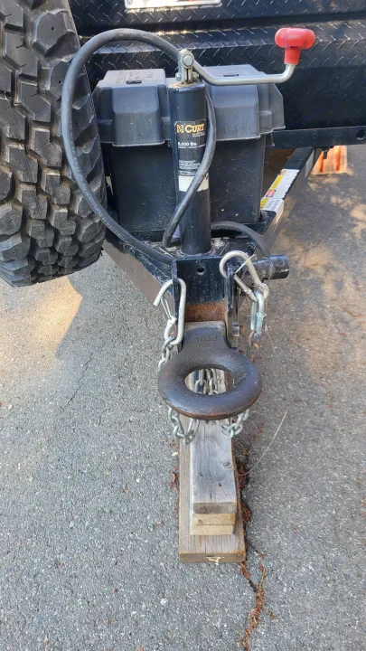 Hitching system of an RV rental trailer showing the heavy-duty pintle hitch, CURT jack, spare tire, and safety chains.. Little Guy Other 2012