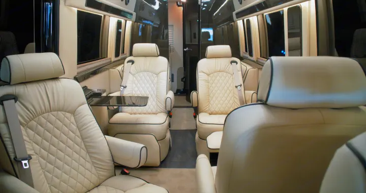 Experience luxury in this RV rental's interior. Cream-colored, quilted captain's chairs and a table offer premium comfort.. Ultimate Toys Ultimate Coach 2023
