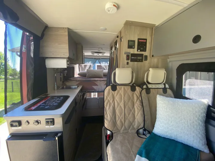 Winnebago RV rental interior: compact camper van with kitchen, bed, and passenger area. Perfect for adventures!. Winnebago Solis 2021