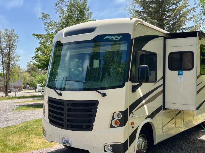A beige Forest River FR3 motorhome RV rental, with extended slide-out, parked at a sunny outdoor campground.. Other Other 2018