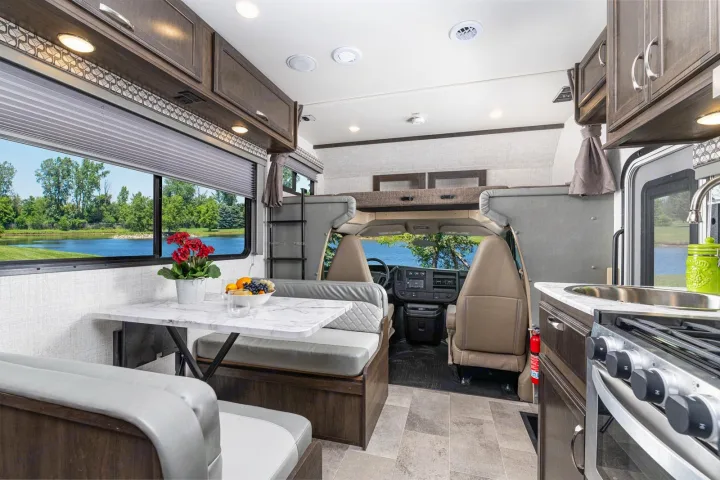 Well-equipped RV rental interior: dinette, kitchenette, overhead bunk, & scenic lake view.. Gulf Stream Conquest 2022