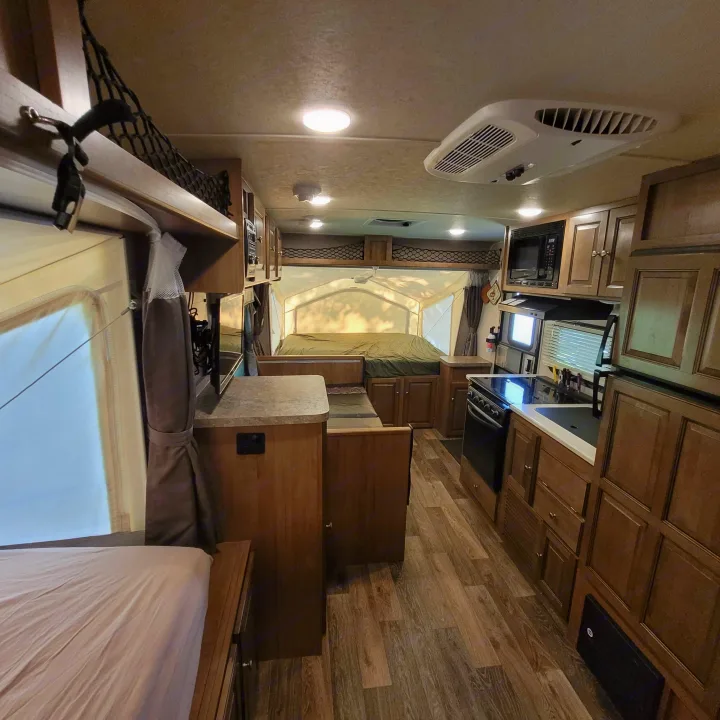 Spacious RV rental interior featuring a modern kitchen, dinette, and cozy pop-out bed area. Perfect for your next trip.. Forest River Rockwood Roo 2017