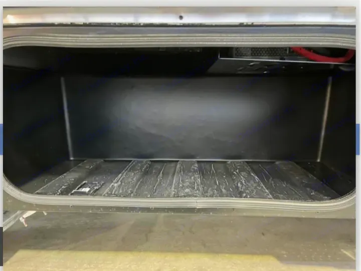 Empty RV rental storage compartment. Dark interior with ridged floor and visible equipment at the top rear. Ideal for gear.. Winnebago View 2023