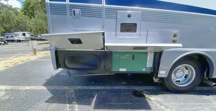RV rental showing its open storage and generator bays, including a Cummins Onan generator, parked at a sunny campground.. Winnebago View 2023
