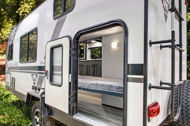 An open RV rental shows a bunk bed inside, with exterior features like utility hookups, windows, and a rear ladder visible.. Heartland RVs Mallard Pathfinder 2022