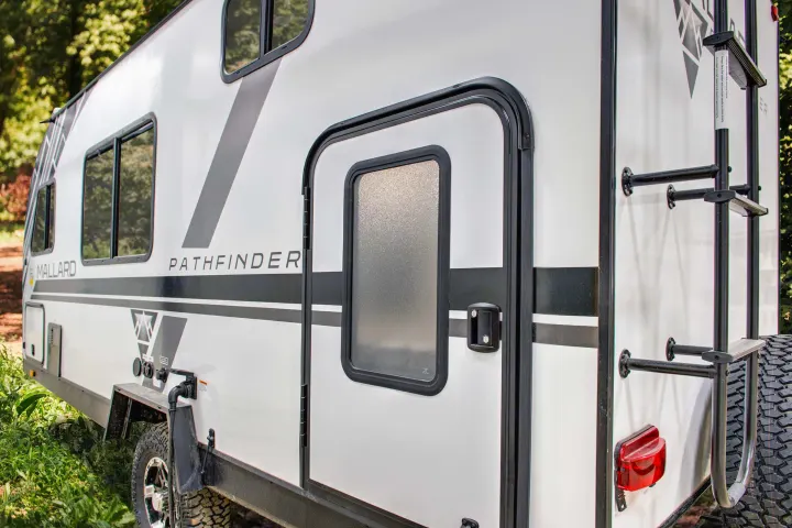 This white Mallard Pathfinder RV rental, with rugged tires and a rear ladder, is perfect for outdoor adventures.. Heartland RVs Mallard Pathfinder 2022