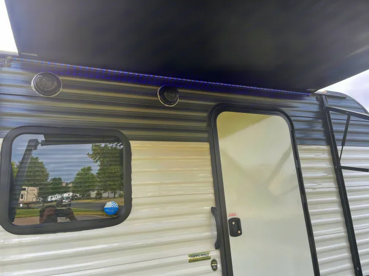 Side of RV rental: extended awning with blue LED lights, outdoor speakers, and windows. Great for camping trips.. Dutchmen Coleman Lantern LT 2021