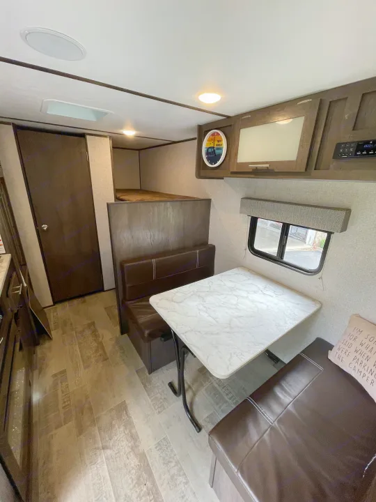 Cozy RV rental interior with a dinette, bunk beds, and compact kitchen. Perfect for a camper adventure.. Dutchmen Coleman Lantern LT 2021