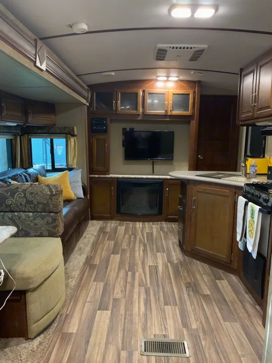 Spacious RV rental interior featuring a cozy living area with TV/fireplace, a functional kitchen, and stylish wood-look flooring.. Other Outback 2017