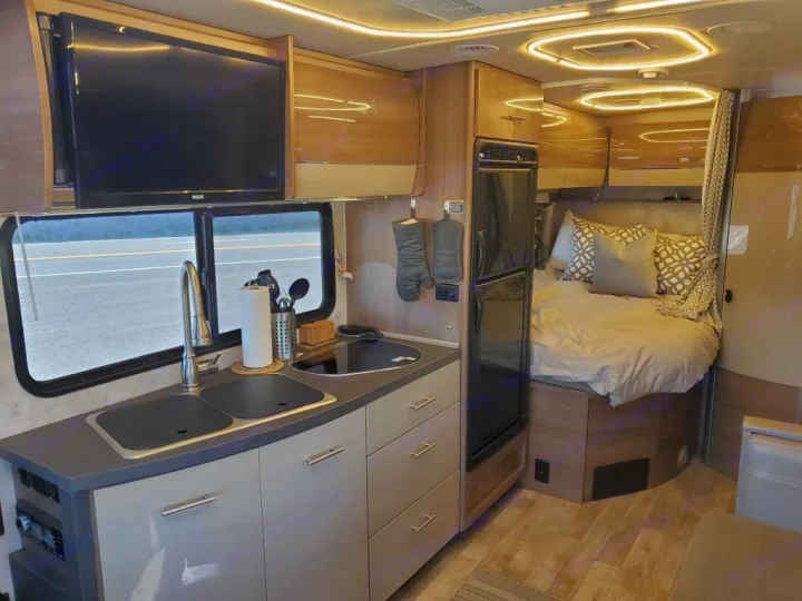RV rental interior: well-appointed kitchen with sink & TV, fridge, and a comfortable bedroom. Perfect for road trips.. Winnebago View 2018