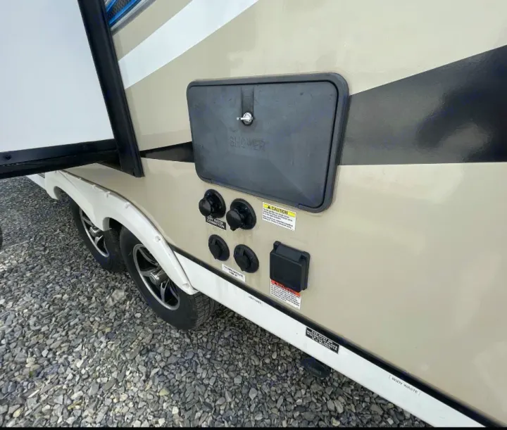 RV rental side: utility connections including city water, tank drains, and power outlet. Features an outdoor shower box.. Coachmen 192 RBS 2018