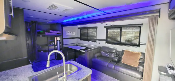 Experience an RV rental! Modern interior with kitchen, dining, comfy sofa, bunks, and cool blue ambient lighting.. Crossroads RV Zinger Lite 2020