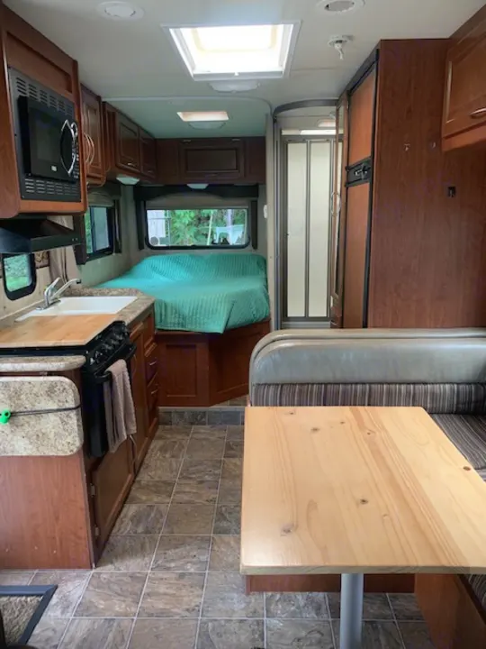 Spacious RV rental interior featuring kitchen, dining, and sleeping areas, ready for your next adventure.. Four Winds Four Winds Motorhome 2011