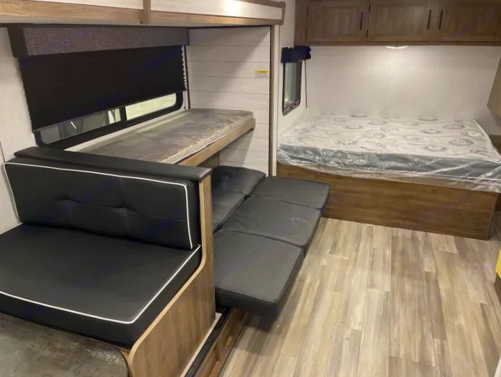 RV rental interior featuring bunk beds, a converting sofa, and a main bed with a covered mattress.. Heartland RVs Pioneer Trail Blazer 2022