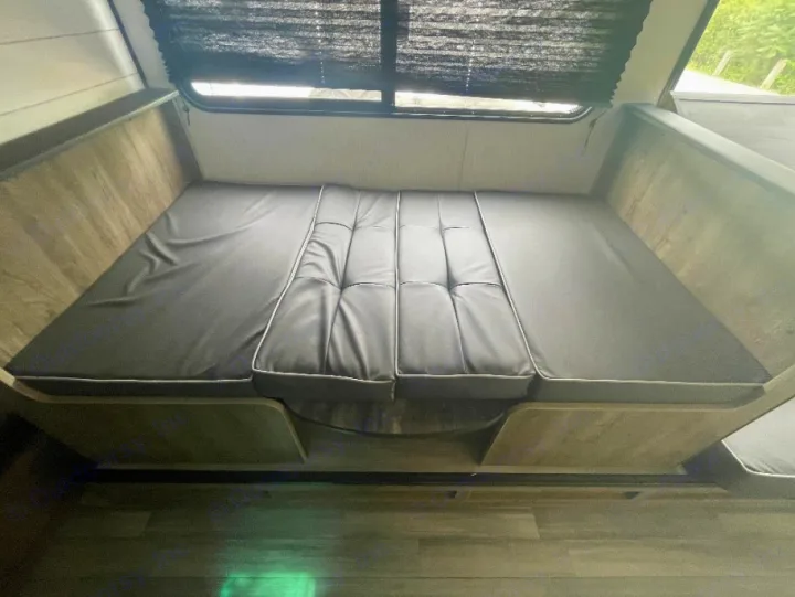RV rental: Dinette with dark gray cushions converts to a bed. Ready for your cozy travel adventures.. Heartland RVs Pioneer Trail Blazer 2022