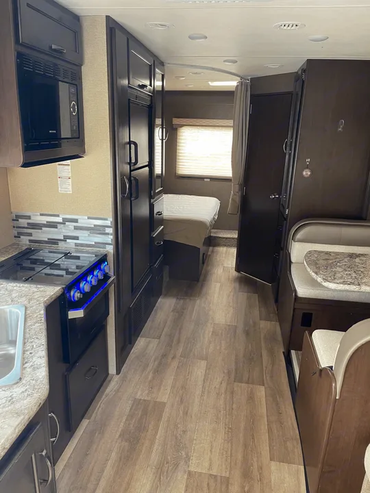 This rv rental offers a compact, functional interior featuring a full kitchen, private bedroom, and dinette area.. Thor Motor Coach Freedom Elite 2019