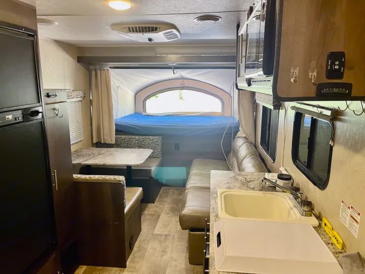 Spacious RV rental interior featuring a kitchen, dinette, sofa, and pop-out bedroom. Ideal for family adventures.. K-Z Manufacturing Escape 2017
