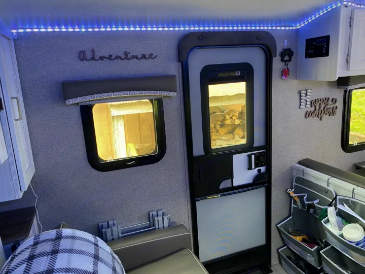 Cozy RV rental interior featuring LED lights, "Adventure" decor, organized storage, and a comfy feel for travel.. Forest River Rockwood 2020
