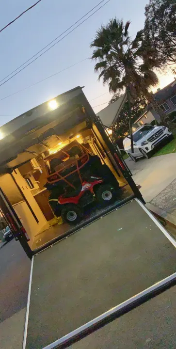 Open RV rental toy hauler, bright interior reveals ATV, UTV, and small kitchen setup for outdoor trips.. Jayco Octane 2019