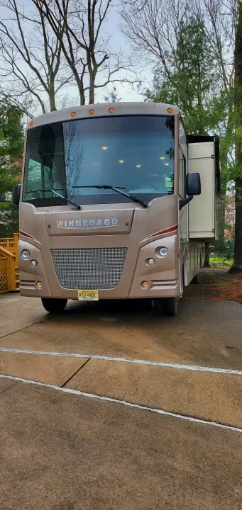 A large beige Winnebago motorhome, ideal for an RV rental adventure, is parked. Its slide-out is extended, ready for use.. Winnebago Vista 2016