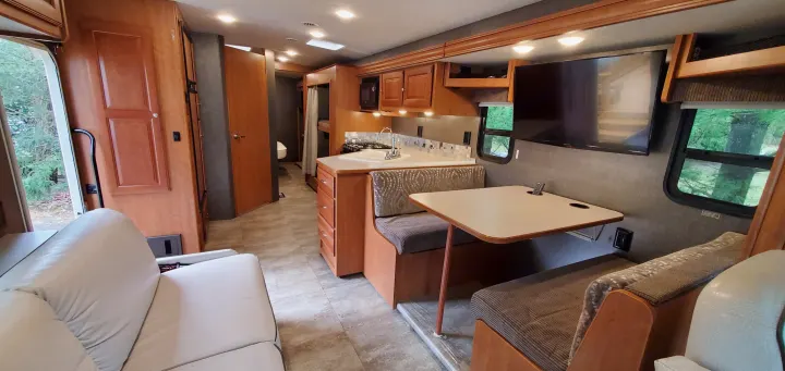 This rv rental's interior boasts a comfortable living area, kitchen, dinette, and compact bathroom.. Winnebago Vista 2016