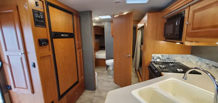 RV rental's interior boasts a full kitchen, refrigerator, private bathroom, and bunk beds.. Winnebago Vista 2016
