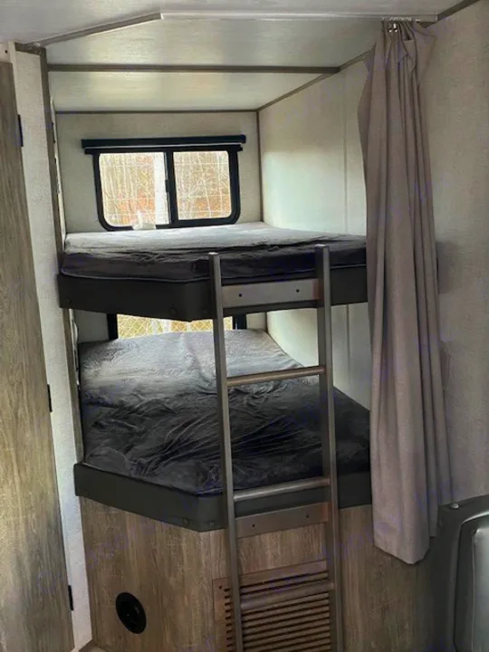RV rental interior: stacked bunk beds with ladder and window, providing practical sleeping space for your next adventure.. Forest River Salem Hemisphere HL 2021