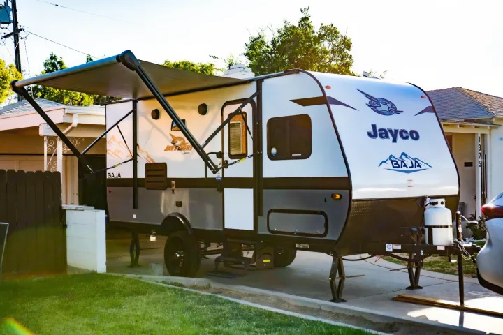 Jayco Jay Flight Baja travel trailer parked in a driveway with an extended awning. Perfect for your next RV rental adventure!. Jayco Jay flight slx 7 2022