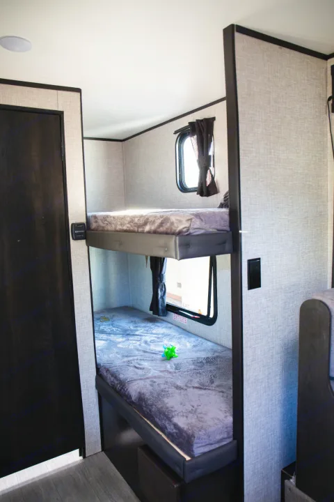 Cozy RV rental interior showing two bunk beds with windows, perfect for extra guests.. Jayco Jay flight slx 7 2022