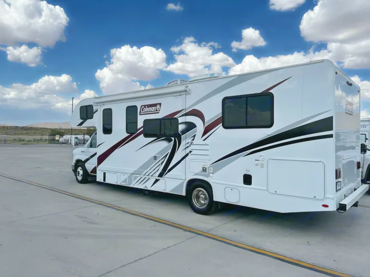 A white Coleman Class C RV rental parked under a bright blue sky with white clouds. Ready for your next adventure.. Coleman Other 2022