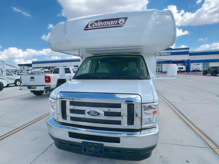 Front view of a white Coleman Class C RV rental on a Ford chassis, parked at a lot with buildings in the background.. Coleman Other 2022