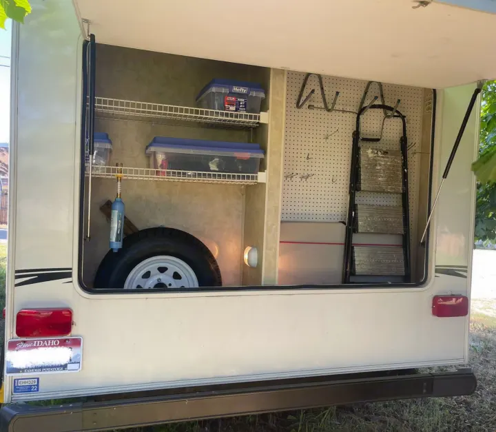 RV rental's spacious, organized rear storage with shelves, bins, spare tire, and a ladder, perfect for camping.. Aerolite Aerolite Trailer 2008