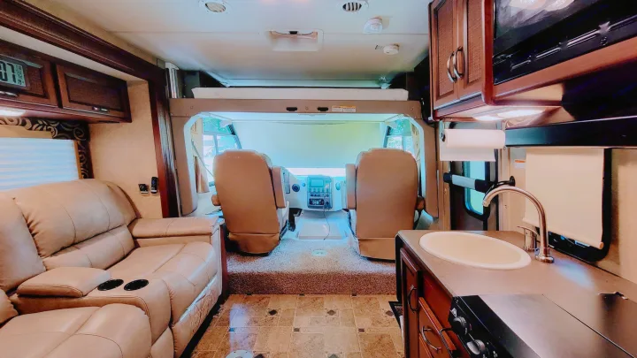 Spacious RV rental interior with living area, kitchen, cockpit, and overhead bunk. Ideal for your next road trip!. Thor Vegas 2014