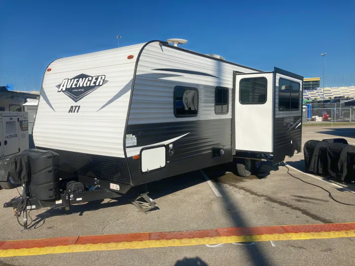 An Avenger RV rental setup with a CAT generator near stadium seating, ideal for temporary event accommodations.. Avenger ATI 2018