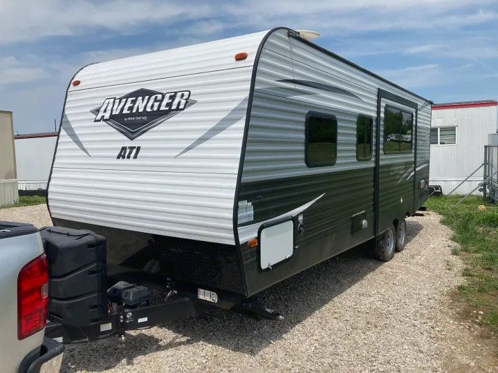 This Avenger travel trailer, perfect for an RV rental, is parked on a gravel lot, ready for your next road trip adventure.. Avenger ATI 2018