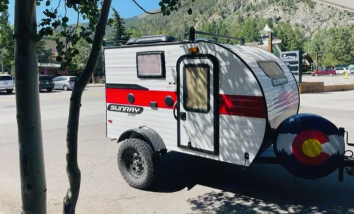 Explore Colorado! This Sunray Sport teardrop camper RV rental with a Colorado flag spare tire cover is perfect for your next adventure.. Sunset Park RV SunRay 2020